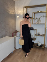 Schwarzes trägerloses Kleid, Marke IHeart, kombiniert mit einer kleine Basttasche von La Milanesa im Naturton und Pantoletten in Schwarz von Lola Cruz